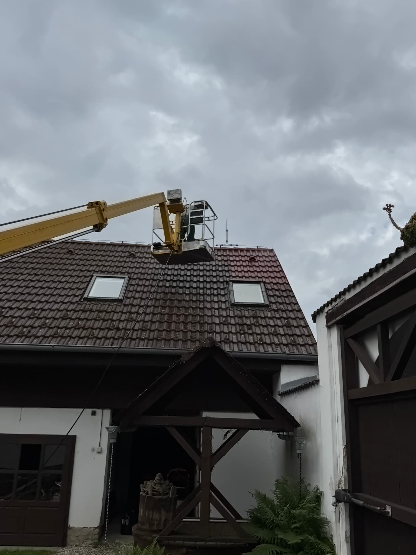 Čištění hnědé střechy z pracovní plošiny
